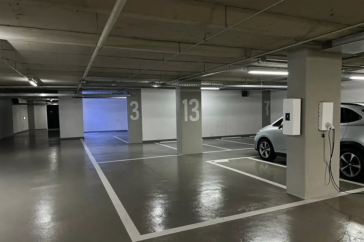 Garagem subterrânea de condomínio com wallbox montada num pilar